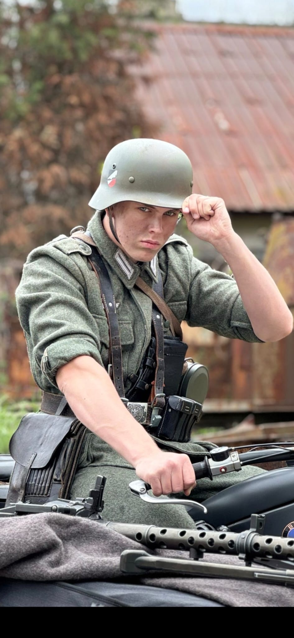 Allegory costume test photograph of an actor in a period military uniform seated on a motorcycle