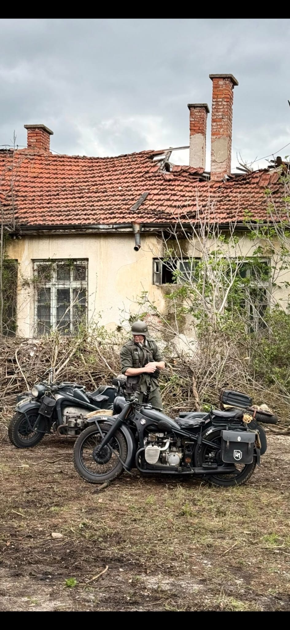 Allegory location test photograph with an actor and motorcycles outside a weathered building